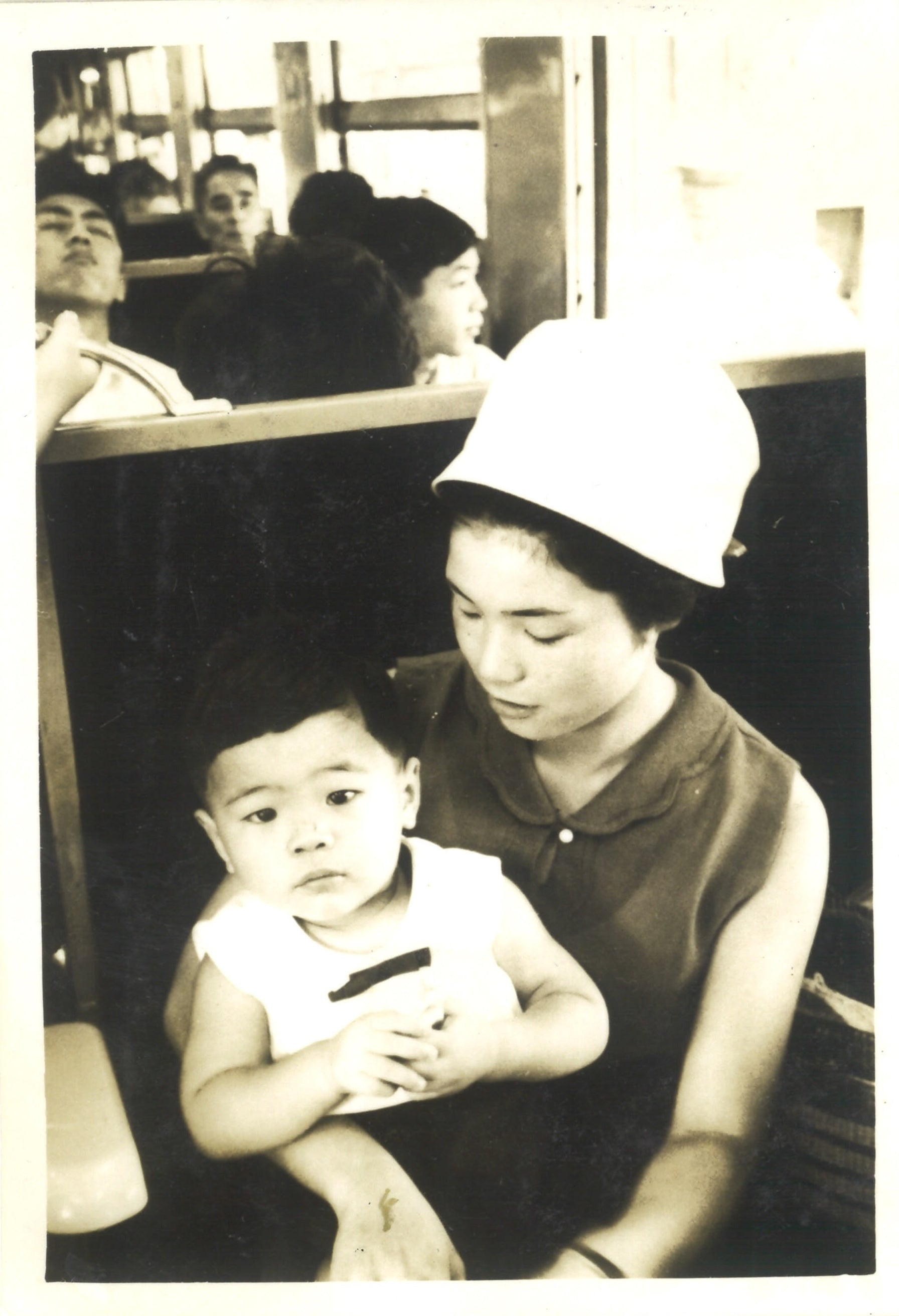 Kitamura is in his mother's arms while on a family trip somewhere.