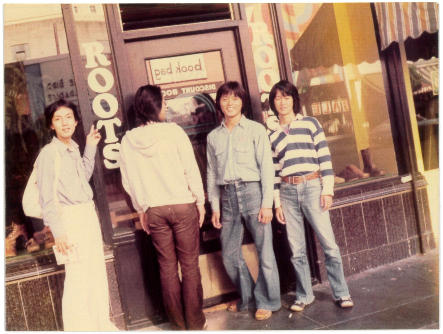 1975年に有田さんと初渡米（サンフランシスコ）。「ハリウッドランチマーケット」の垂水（ゲン）さんに教えてもらった、ポークストリートにあるアースシューズで有名な〈ルーツ〉のショップ前で。