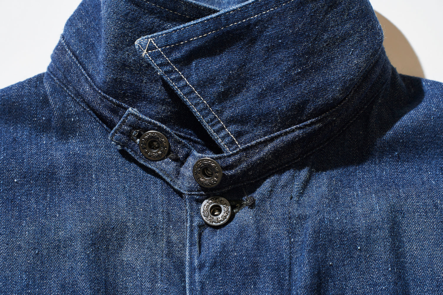 The neck has an old detail with a narrow space between the first and second buttons.