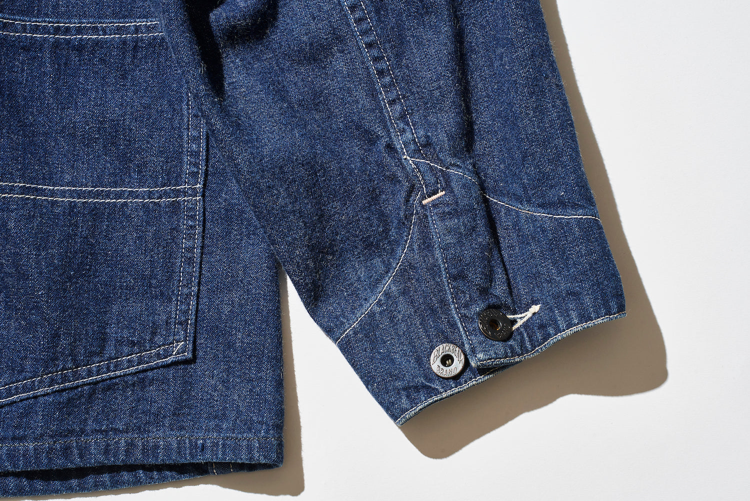 The cuffs are adorned with hammered donut buttons engraved with “BLACKBEAR BRAND.”