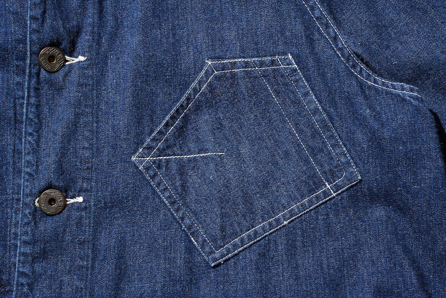 There is a modified diagonal pocket on the left chest. It has a pen holder and stitching to prevent a pocket watch from falling out.