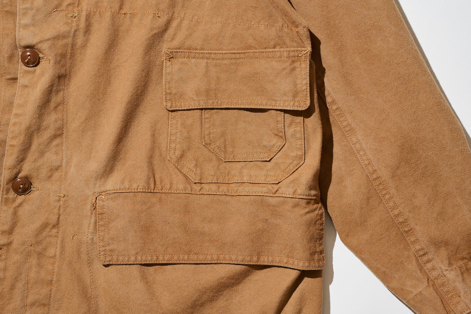 Two flap pockets are located near the left armpit. The upper pocket is a double-layered functional pocket, while the lower pocket is a large-capacity pocket.