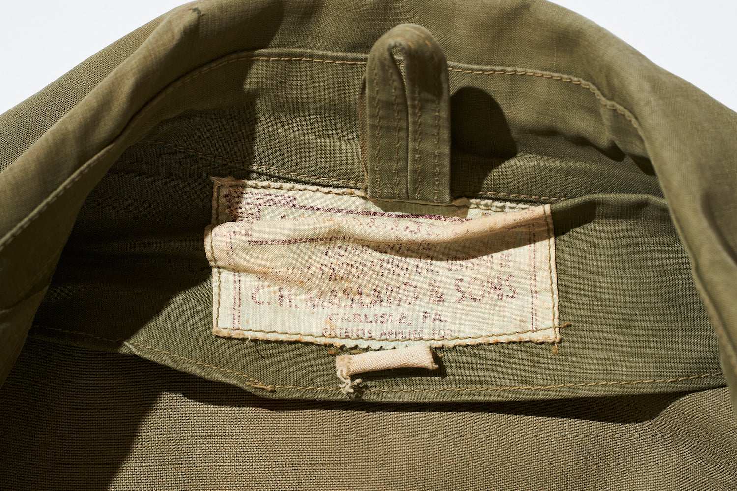 The cloth brand patch is reminiscent of military wear. In addition to the brand name, the print also includes the letters 