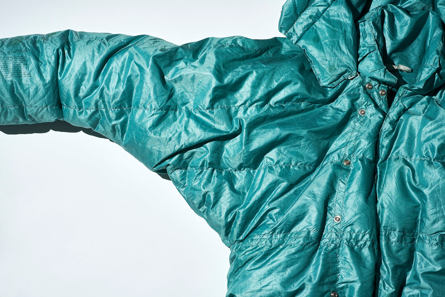 The straight quilting lines around the shoulders show that the pattern of a sleeping bag has been directly applied to the garment.