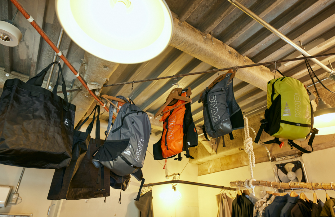 Hanging from above is a backpack from OMM, a UK brand born out of a mountaineering event that has been running since 1968. The brand develops items based on the concept of producing gear and clothing that can withstand the harsh mountain races known as the Original Mountain Marathon.