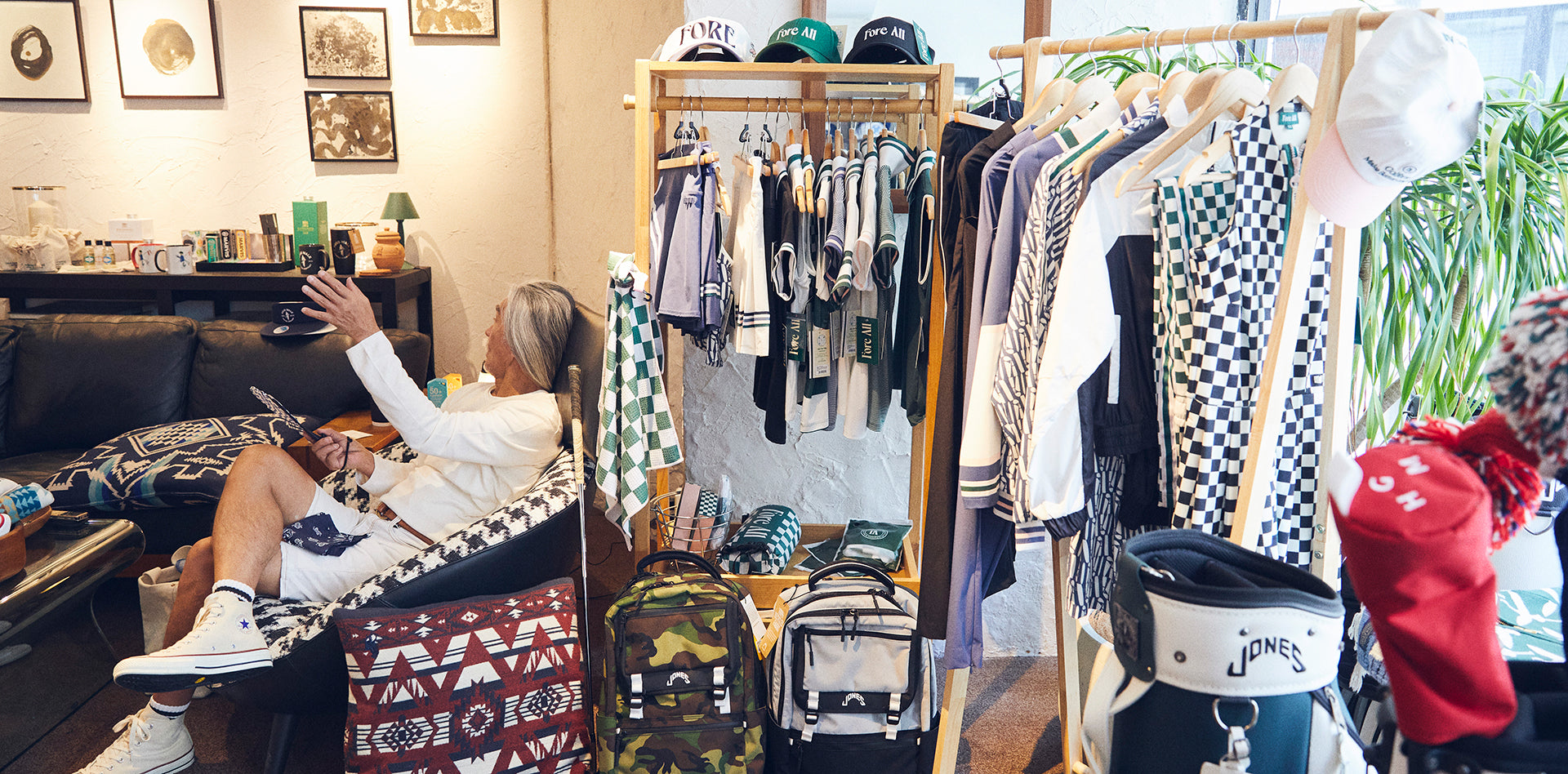 色とりどりのアイテムに囲まれながら、定位置のソファに座るオーナーの堀川恭資さん。