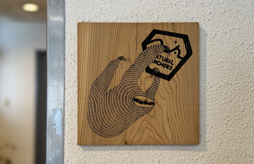 店舗入口に掲げられたナマケモノの看板。オーナーがクライマーだったことに由来する。