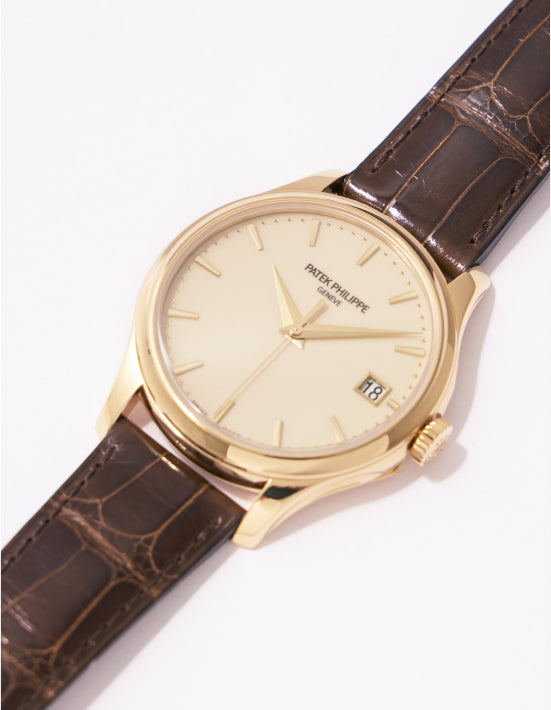 The 18K yellow gold case measures 39 mm, and the ivory dial has a date window.